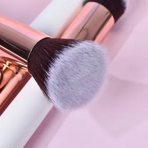 Dettaglio ravvicinato delle setole sintetiche morbide e della ghiera in oro rosa di un pennello