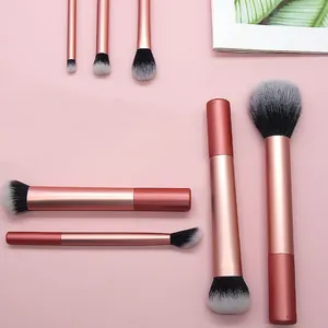 Detail van zachte kleurverloopborstels en metallic roségouden handgrepen van een make-up set