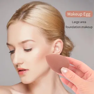 Primo piano di una modella che usa una spugnetta per trucco per il fondotinta viso