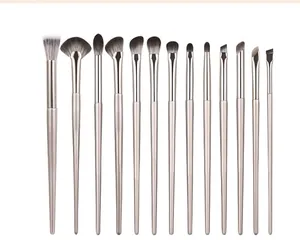 Detailed view of fifteen professional makeup brushes with champagne gold handles on white
