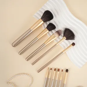 Detailweergave van een goudkleurige make-up borstelset op een elegante displayplaat
