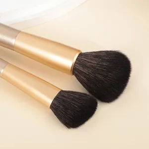 Macro-opname van twee luxe make-upborstels van dierenhaar met elegante gouden ringen.