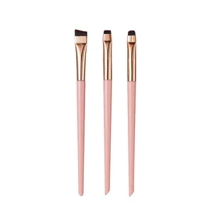 Close-up detail of three professional pink makeup brushes for eyeliner and concealer application