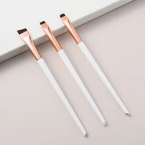 Close-up of three professional eyeliner and detail makeup brushes in rose gold and white.