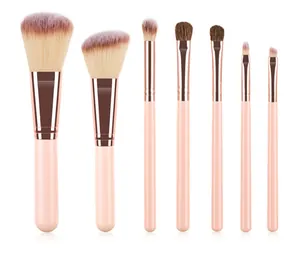 Sieben-teiliges Make-up-Pinsel-Set mit rosa Griffen und roségoldenen Zwingen auf Weiß