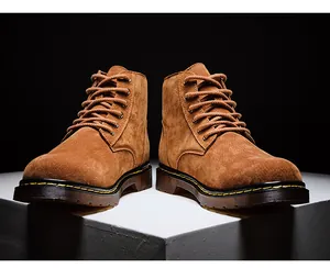 Gros plan de bottines en daim marron pour hommes avec surpiqûres jaunes et lacets