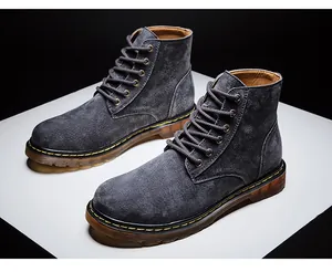 Vue détaillée des bottines en daim gris foncé avec des surpiqûres jaunes élégantes