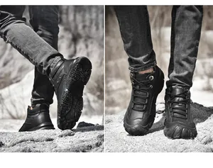 Detailed view of durable black leather hiking boots on rugged rocky outdoor terrain