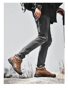 Side detail view of brown genuine leather hiking boots worn on rugged outdoor rocky terrain