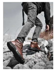 Detailed view of brown leather hiking boot showing sole traction on rugged mountain rocks.