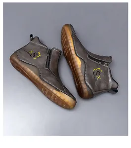 Detailed view of grey mid-top casual men's boots with side zipper and yellow sole