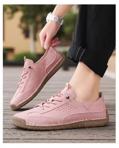 Close-up of pink leather casual shoes with hand-stitched details and lace-up design.