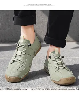 Close-up of sage green leather casual loafers on feet in a natural outdoor setting