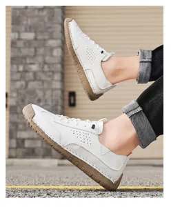 Detail of white leather casual shoes with brown stitched soles and perforated design