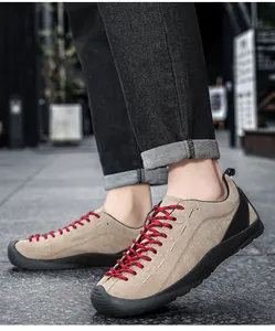 Vue latérale de baskets décontractées en daim kaki avec lacets rouges et noirs