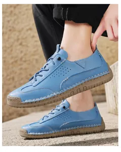 Detailed view of blue leather casual shoes featuring hand-stitched brown rubber soles.