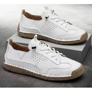 Detailed view of white leather casual loafers with hand-stitched tan soles