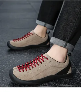 Gros plan de chaussures décontractées en daim kaki avec lacets rouges et denim noir