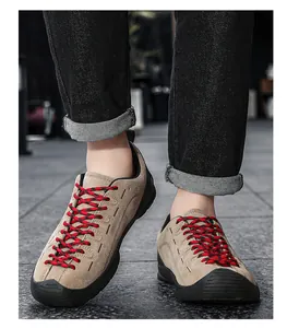 Vue détaillée de chaussures décontractées en daim beige avec lacets rouges et jean noir.