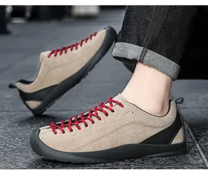 Gros plan de chaussures décontractées en daim kaki avec lacets rouges et semelle en caoutchouc noir.