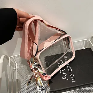 Dettaglio borsa in PVC rosa trasparente con ampia tracolla e foulard di seta.