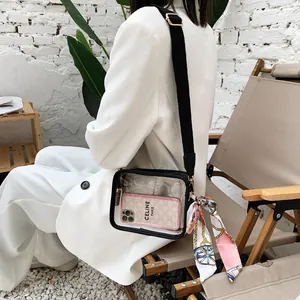 Dettaglio della borsa a tracolla in PVC trasparente con tracolla larga nera e foulard