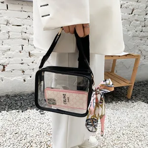 Vista dettagliata di una borsa a tracolla in PVC trasparente con bordo nero e foulard decorativo.