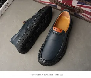 Vista dettagliata di scarpe da uomo in pelle blu navy cucite a mano su pavimento grigio