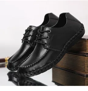 Vista detallada de zapatos casuales de cuero negro para hombre con costuras a mano.