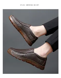 Detailed view of brown textured leather loafers with hand-stitched seams and rubber sole.
