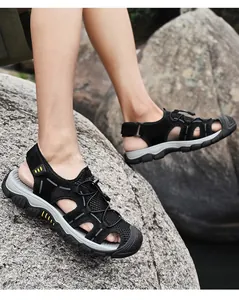 Gros plan de sandales de randonnée noires respirantes pour hommes sur des rochers
