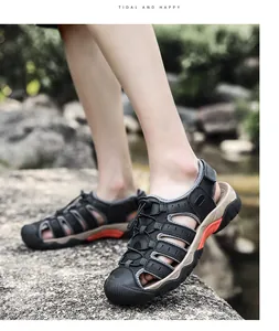 Vista lateral de sandalias de senderismo cerradas negras para hombre sobre rocas