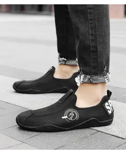 Λεπτομερής πλάγια όψη μαύρων ανδρικών casual loafers με λογότυπο μάρκας στο πεζοδρόμιο
