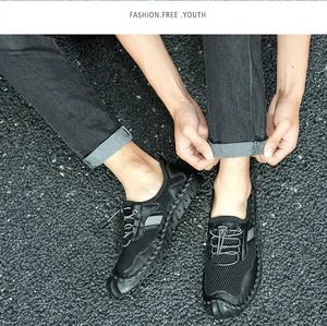 Détail de chaussures de randonnée en maille noire respirante pour hommes avec lacets.