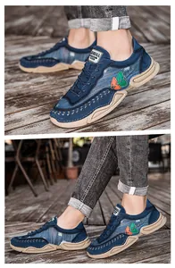 Close-up of men's navy denim casual sneakers with beige soles on a wooden deck