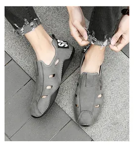 Gros plan de chaussures décontractées en cuir gris ajouré pour hommes portées à l'extérieur.