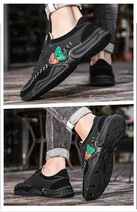 Close-up of black men's casual sneakers with textured non-slip rubber soles for outdoor.
