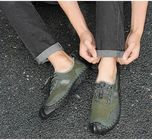 Détail de chaussures de randonnée en mesh vert respirant pour hommes avec lacets.