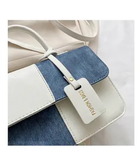 Détail d'un sac bandoulière patchwork bleu et blanc avec une texture élégante.