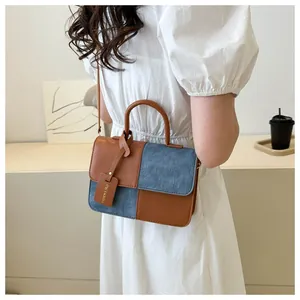 Vue détaillée du sac à bandoulière en patchwork marron et denim avec poignée supérieure