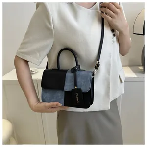 Modèle tenant le sac à main carré tendance en patchwork denim et cuir noir pour femme