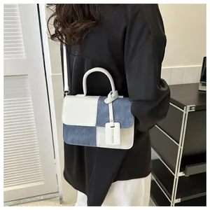 Mannequin portant un petit sac à main patchwork bleu et blanc au style moderne.
