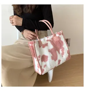 Detaillierte Ansicht der großen flauschigen rosa Kuhmuster-Tasche, von Model getragen