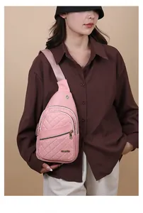 Detailed view of pink quilted chest bag worn by a model in a brown shirt.
