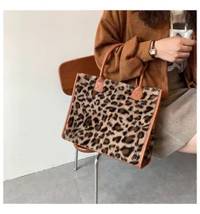 Modische Leopard-Plüsch-Tragetasche mit braunen Griffen für den Herbst und Winter.