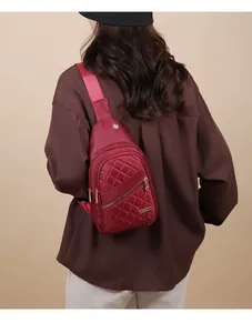 Close-up detail showing the texture of a wine red quilted chest bag worn as a crossbody.