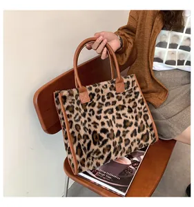 Große Tragetasche mit Leopardenmuster aus Kunstfell in den Händen eines Modells