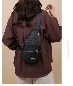 Model wearing a stylish black quilted sling chest bag with luxury gold zipper details