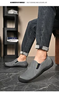Vue détaillée de chaussures décontractées grises en daim pour hommes portées au pied