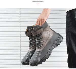 Vue détaillée de bottes montantes en cuir pour hommes tenues à la main avec semelles